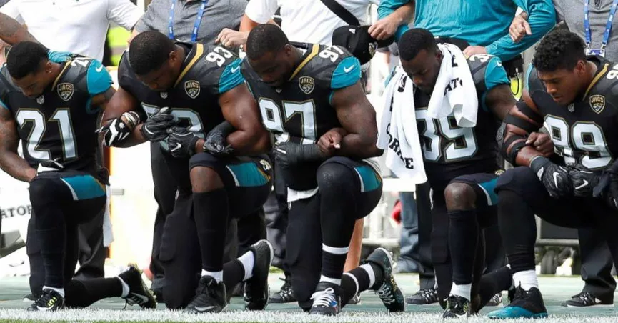 players kneeling before the football game